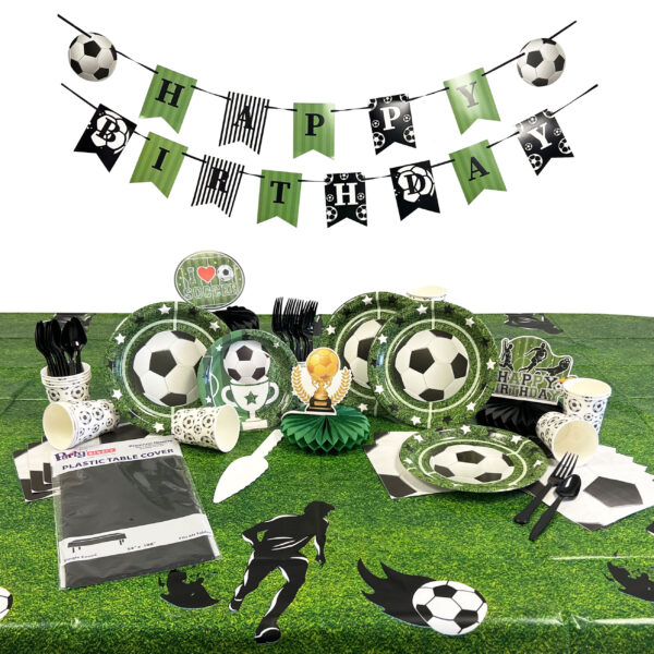 Soccer-themed birthday party decorations featuring a "Happy Birthday" banner, football plates, cups, utensils, a trophy centerpiece, and grass-patterned table cover.